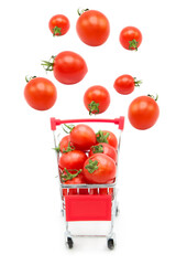 Supermarket shopping cart with ripe fresh tomatoes with tomatoes flying into it isolated on white background. Organic and environmentally friendly vegetables.	