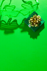 Image of green clover glasses with green present and copy space on green background © vectorfusionart