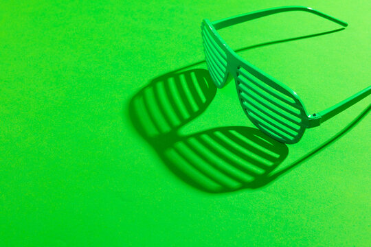 Image of green glasses and copy space on green background
