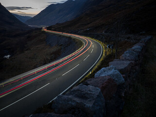 Glen Coe at night with car light trail