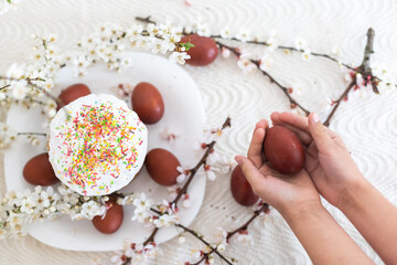 hands holding painted eggs. Easter cake