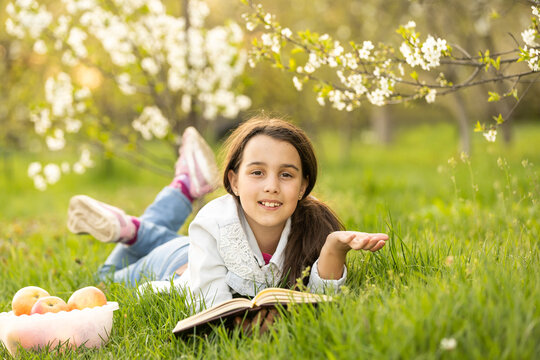 little girl with a bible in the garden, praying, dreaming outdoors.