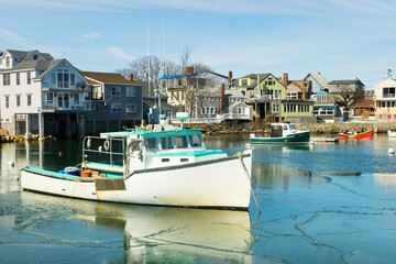 Lobster boats in the frozen inner harbor of Rockport at the tip of the Cape Ann peninsula on Atlantic coast of Massachusetts, USA