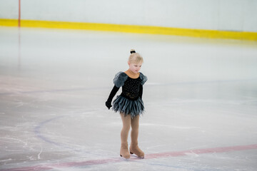 Figure skating of a little 4 year old girl. First competition. Excitement, pride.