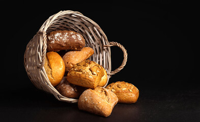 Basket with appetizing rolls on a black background