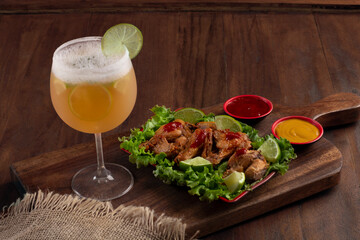 Beer mug on wooden board with portion of fried chicken