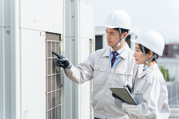 室外機のメンテナンスをする作業員