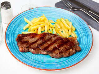 Tasty grilled beef tenderloin with french fries served at plate