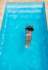 gente en piscina con agua celeste en verano alegria
