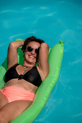 gente en piscina con agua celeste en verano alegria