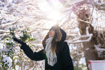Young Asian woman in black coat looking beautiful nature in forest mountain covered in snow in...