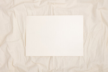 Blank note paper on a fabric background.
