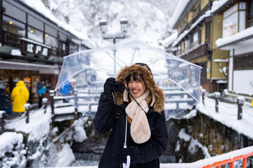 Asian woman tourist using digital camera taking picture during travel Ginzan onsen area in Yamagata...