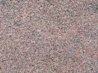 Granite texture. Natural pink granite with a grainy pattern. Stone background. Solid rough surface of rock. Durable construction and decoration material. Close-up.