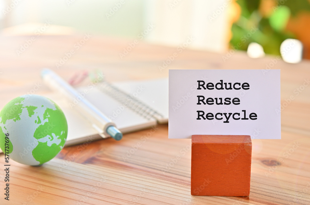 Poster there is a piece of paper with the word reduce reuse recycle. it is eye-catching image.