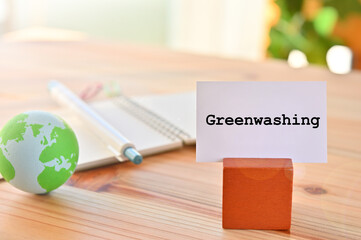 There is a piece of paper with the word Greenwashing. It is eye-catching image.