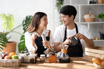 Young smiling couple in love spending a weekend morning together while making coffee at the kitchen, having breakfast together.