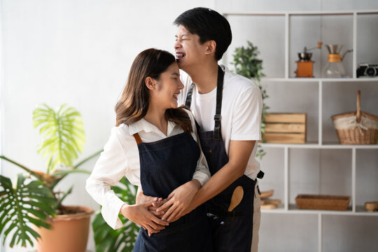 Young Asian couple spending their quality time together in the modern kitchen room, preparing their delicious food together.