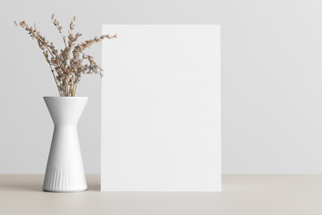 White invitation card mockup with a lavender on the beige table. 5x7 ratio, similar to A6, A5.