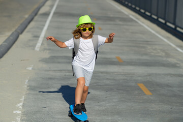 Kid boy riding skateboard in the road. Kid practicing skateboard. Children learn to ride skateboard in a park on sunny summer day. Active leisure and outdoor sport for child.