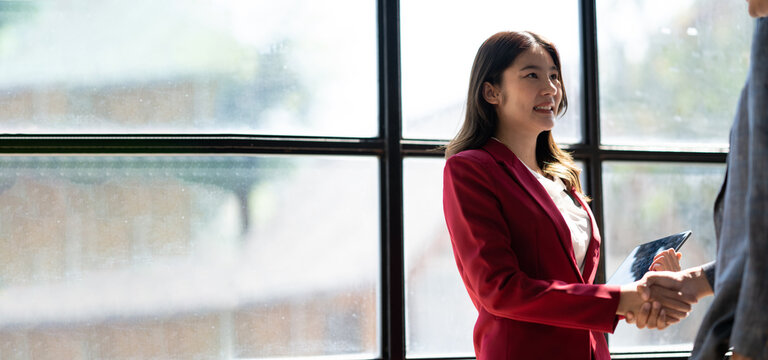 Business people are shaking hands in office. Collaborative teamwork.