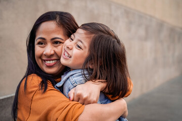 Happy Asian mother and daughter having fun together outdoor - Focus on mom hands