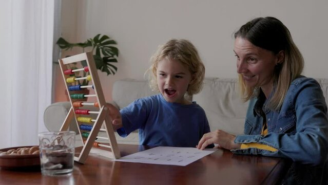 Mother and son studying math with abacus for school class inside home - Family and love concept