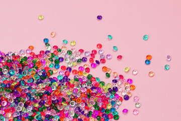 Multicolored tiny faceted crystals on a pink background, beautiful colorful texture