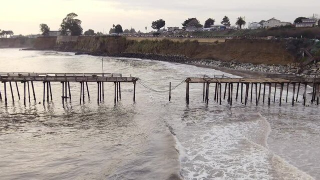 Capitola Wharf - Part Of Fishing Pier Collapsed Into The Ocean, Caused By The Storm And Powerful Tidal Surges In California, USA. aerial ascend tilt-down