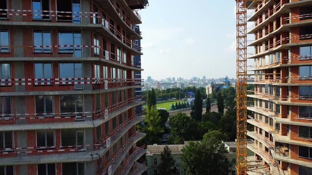 Drone rising in front of two buildings under construction in city center to reveal beautiful cityscape of Kyiv, Ukraine. Aerial 4k