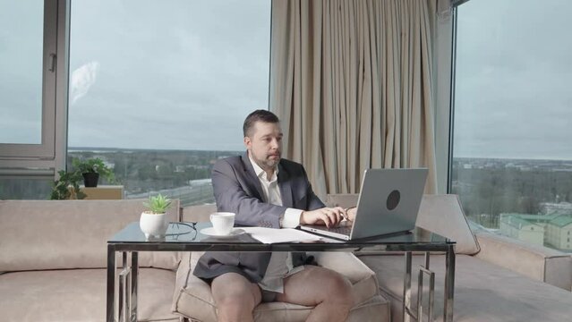 Man in suit without pants working online. home office, video conference, self-isolation concept. Businessman working at home. Remote work, work on the Internet, remotely