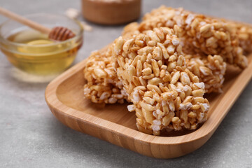 Plate with puffed rice pieces (kozinaki) on grey table, closeup