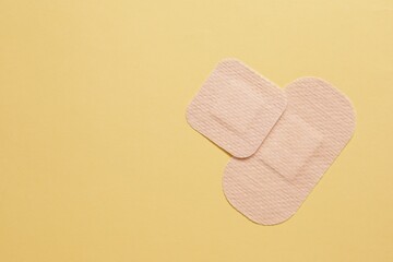 Different contraceptive patches on yellow background, flat lay. Space for text