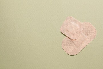 Different contraceptive patches on green background, flat lay. Space for text