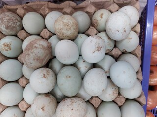 Duck fresh eggs pile for sale at a market as background