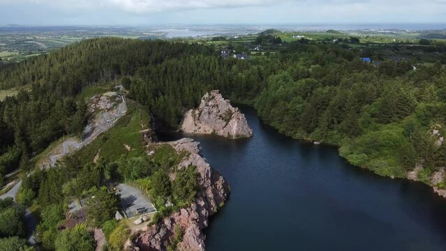 Beautiful lowering aerial shot of old Irish quarry as clouds pass overhead