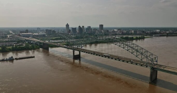Memphis Tennessee Aerial v35 flyover mississippi river and hernando de soto bridge capturing downtown cityscape and a pusher boat pushing a barge on the waterway - Shot with Mavic 3 Cine - May 2022