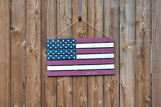 The Stars and Stripes: Faded Wooden American Flag Hanging on a Wood Fence