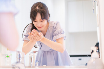 家で洗顔をする若い女性