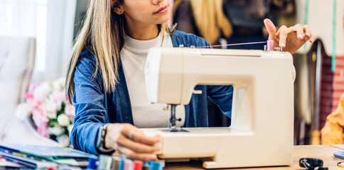 Portrait of young beautiful woman fashion designer stylish sitting and working with color samples.Attractive young girl working with colorful fabrics at fashion studio