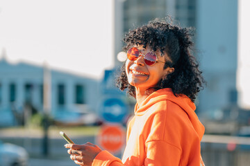 afro american girl in street with mobile phone