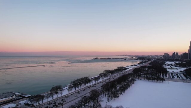 flying backwards over Lakeshore Drive highway from chicago and Lake michigan at the sunset, rush hour. Aerial 4k