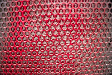 red Metal with holes close up abstract detail background