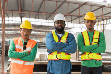 Foreman builder and workers standing together at construction site. Group of diverse construction site workers or controller working at construction site