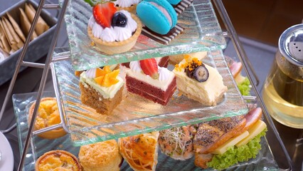 Close-up of delectable tier of macarons, scones, and petits cakes desserts