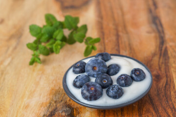 blueberries with yogurt on a black plate