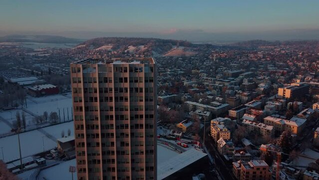 Beautiful view of a winter sunrise over the city center of Winterthur, Switzerland. Aerial view, flying by the Wintower, Sulzer Hochhouse. Canton of Zurich