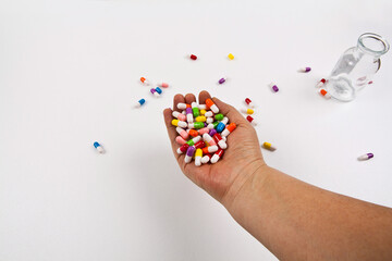 Colorful pills and medicines are placed on the hand. It is separated from the background and can be...