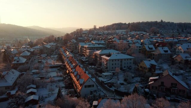 Snowy day, sunrise over the roofs of Winterthur. flight over the Suburbs in the hills. Switzerland, Canton Zurich