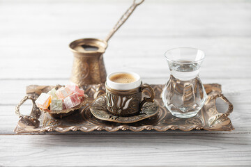 Cup of coffee and glass of water and lokum on saucer ready to eat for iftar time. Islamic religion and ramadan
